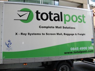 The Queen's Award logo on the side of a Totalpost van.