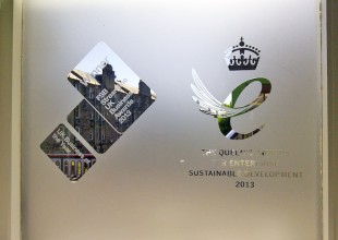 The Queen's Awards logo engraved on a window.